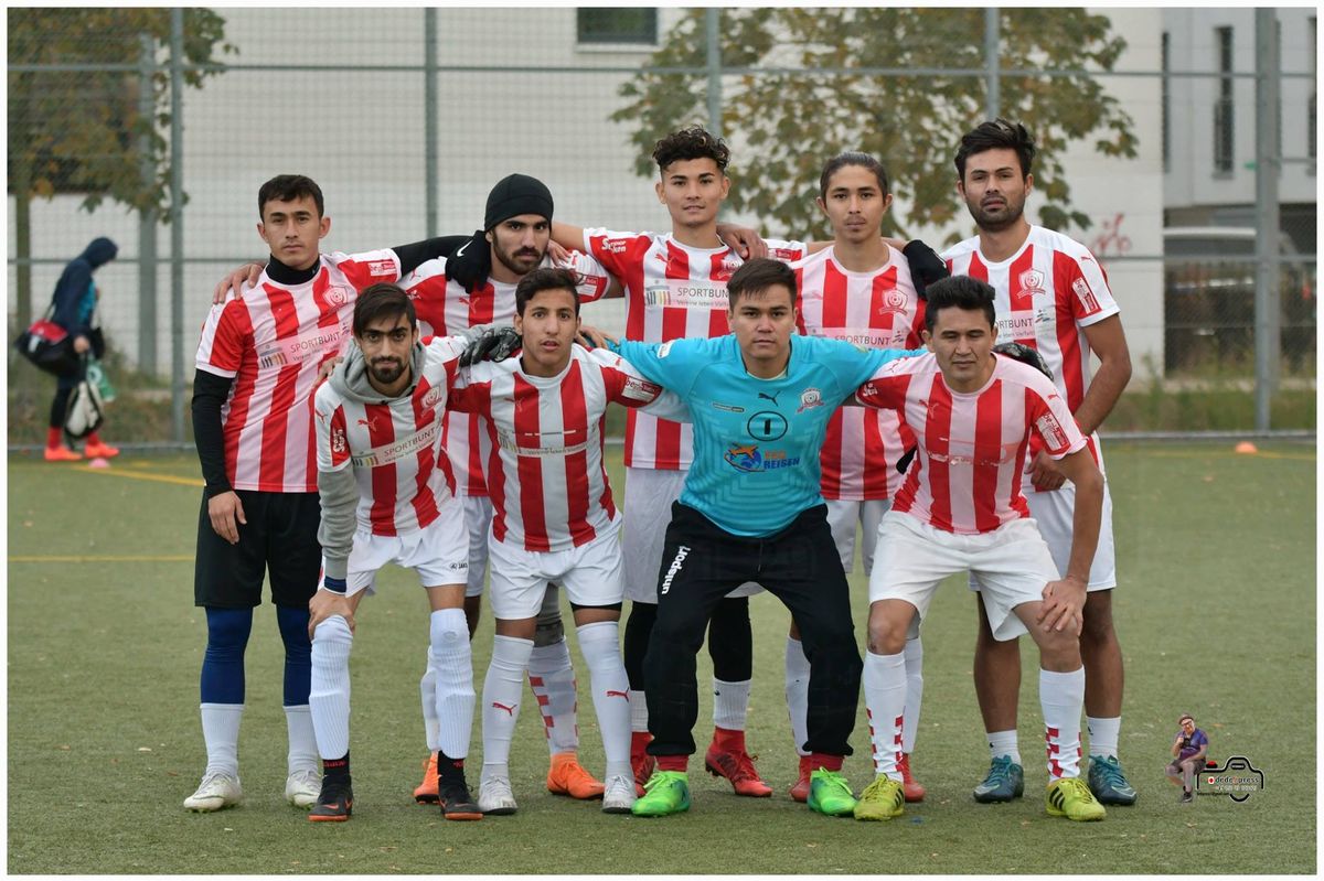 Neun junge Männer in rot-weiß gestreiften Trikots formen das Heimteam FC Yaran der TSM Fußballakademie